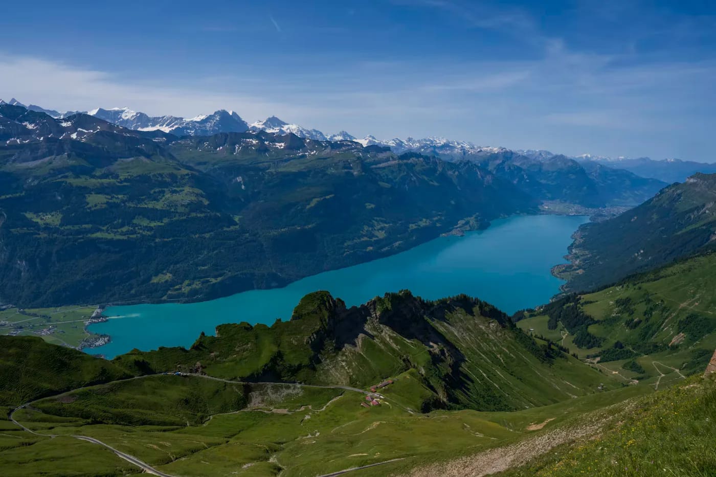 A turquoise Swiss lake viewed from green mountain slopes